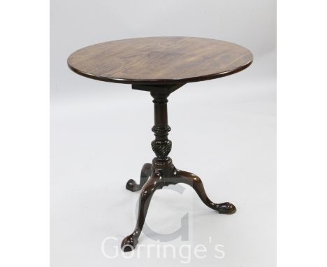 A George III mahogany tea table, with circular top and birdcage, on turned spiral fluted baluster stem with downswept tripod 