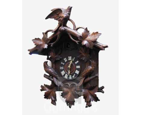 A Black Forest carved wood cuckoo clock, with two singing birds and bird and foliage carved case, height 23in.