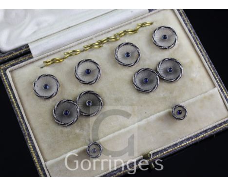 A 1920's cased 18ct gold, frosted glass and blue cabochon set eight piece dress stud set, of circular form with illusion set 