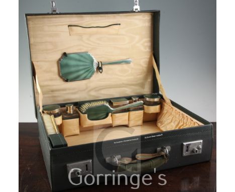 A 1930's silver and green guilloche enamel travelling toilet set by Goldsmiths and Silversmiths Co Ltd, comprising five mount