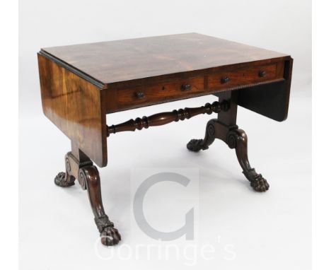 A Regency rosewood sofa table, with rounded flaps and two frieze drawers, on end standards with downswept legs and scroll car