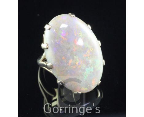 A large 9ct gold and opal dress ring, the claw set oval stone measuring 30mm by 22mm by 5mm, size O.