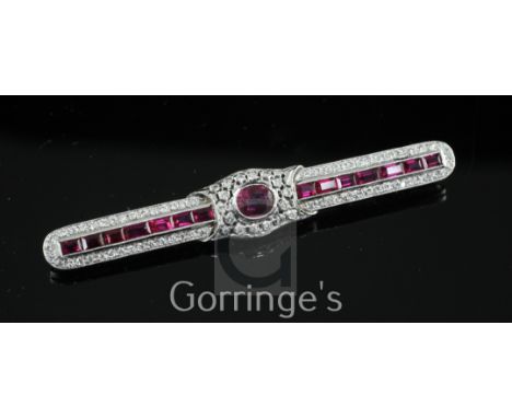 A mid 20th century white gold, ruby and diamond encrusted bar brooch, set with oval and baguette cut rubies and round cut dia