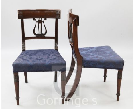 A pair of Regency mahogany dining chairs, with Greek key carved cresting rails, lyre shaped splats and padded seats, on ring 
