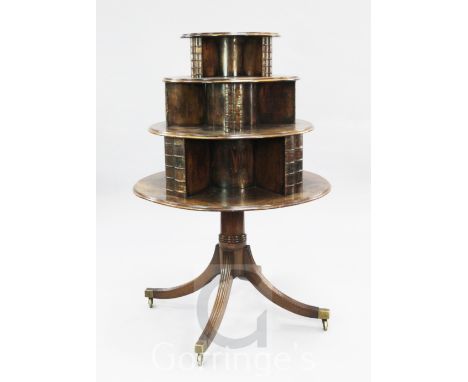 A George III mahogany revolving bookcase, c.1810, with circular graduated three tier top, with faux binding divisions, on rin