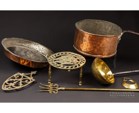 Seven brass and copper items, including a copper skillet and pan, brass ladle and pot stand. (7)