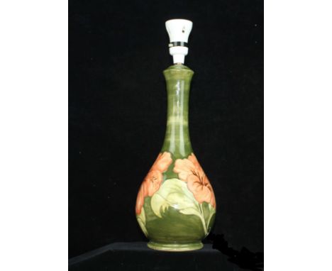 A Moorcroft Pottery  table lamp, Coral Hibiscus pattern, on leaf green ground,  bottle form, c1950, impressed mark and paper 