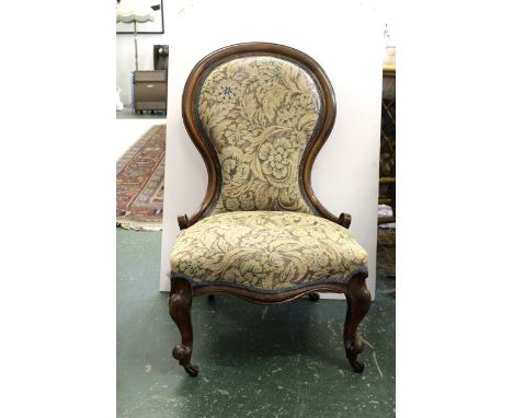 An Edwardian spoon back nursing chair, carved front legs and plain rear legs - tapestry upholstered with original castors