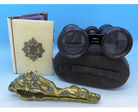 A brass nutcracker, a pair of theatre glasses, Jumelle De Paris, cased, and a notebook