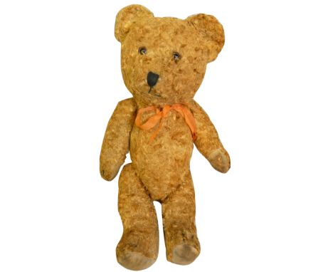 A vintage straw filled teddy bear, with gold coloured fur and orange bow, height 38cm.  