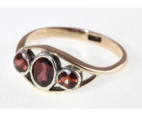 A garnet set three stone ring marked 9ct, approx 1.9g, size M