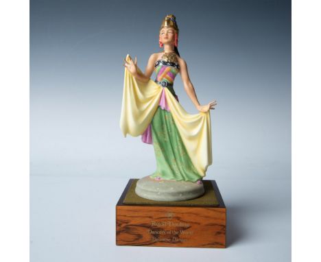 This figurine features a woman in a traditional costume, wearing a gilded hat and necklace, captured in a dancing pose. Royal