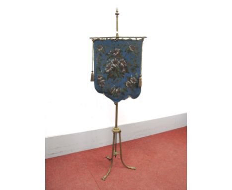A XIX Century Gilded Brass Firescreen, with a finial top and beadwork floral shield shaped panel, on scroll feet.