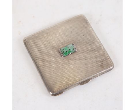 An Elizabeth II engine turned rectangular silver compact, the lid set with a carved and pierced jade panel, width 7.5cm, Lond