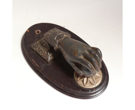 A 19th century cast-iron figural hand and ball door knocker, on a stained mahogany plaque, plaque height 24.5cm 