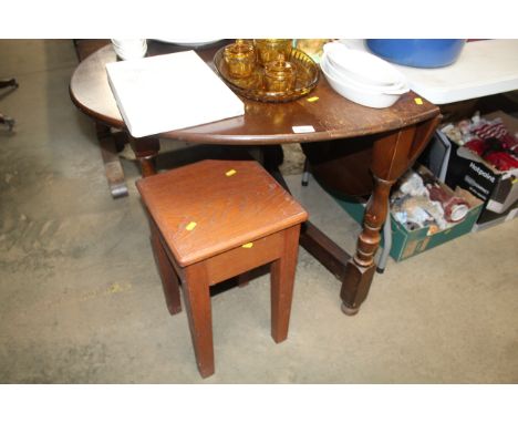 An oak gate legged table together with a stool