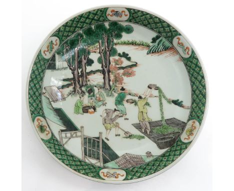 Famille Verte decor, depicting men working in garden, marked on bottom with double ring and 6 characters, 39 cm. in diameter.