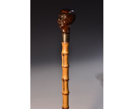 A 19th century novelty walnut and bamboo walking stick, the pommel carved as a grotesque sticking his tongue out, bamboo shaf