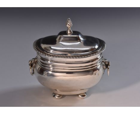 An Edwardian silver boat shaped tea caddy, of George III design, hinged domed cover with spiral knop finial, gadrooned border