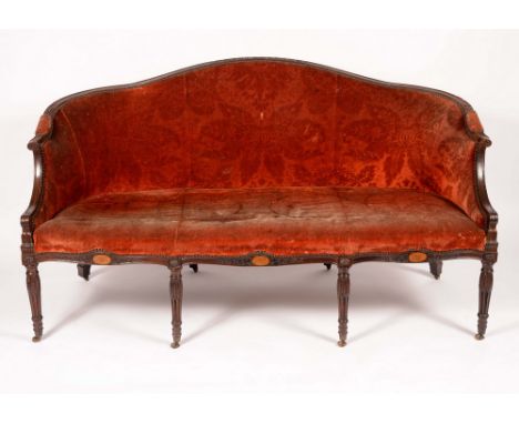 A George III Hepplewhite period mahogany sofa, curved serpentine back carved sparingly with acanthus, stuffed-over plum velve