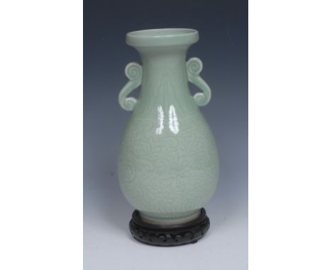 A Chinese celadon ovoid vase, incised with lotus leaves and scrolling foliage, scroll handles to shoulders, 25cm high, six ch