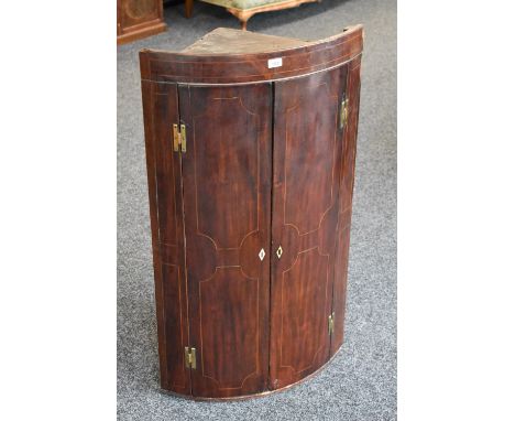 A George III mahogany bow fronted cabinet, satinwood inlay enclosing one drawer and shelf, c.1820