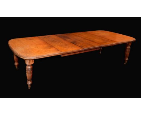 A Victorian mahogany rounded rectangular wind-out dining table, moulded top above a deep frieze, turned and fluted legs, cera