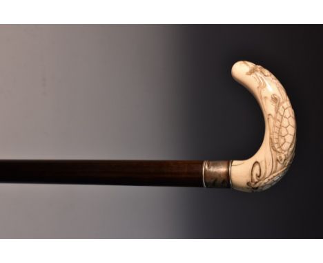 A Japanese ivory walking stick, the crook handle carved in relief with sea turtles, silver collar, hardwood shaft, silvered s