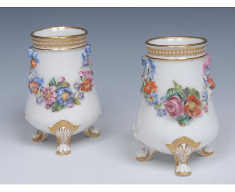 A pair of Royal Worcester spreading cylindrical vases, encrusted with ribbon tied colourful floral swags, three beaded gilt a