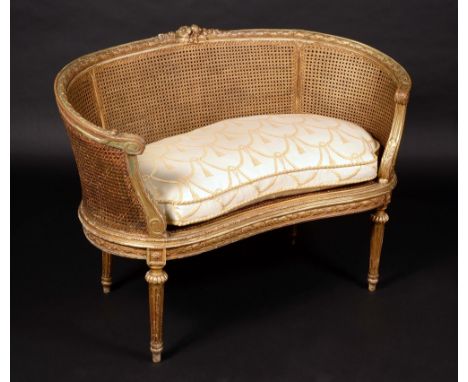 A Louis XVI Revival giltwood gesso kidney-shaped bergere sofa, carved with fruiting laurel, flowers and acanthus scrolls, squ