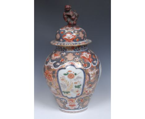 An early 18th century Japanese Export Imari baluster ginger jar and cover, painted with four lobed reserves of chrysanthemums