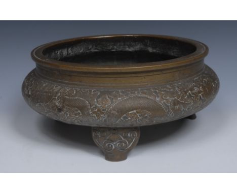 A Ming style Chinese bronze ding, cast with dragons and flowers and scrolls, three scroll feet, 30cm diam,  Zhengde marks but