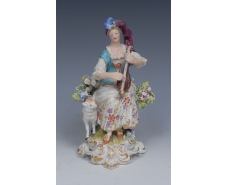 A Derby Patch Mark figure, of a Musician, seated playing a mandolin, wearing a blue corsetted and floral dress, a lamb at her