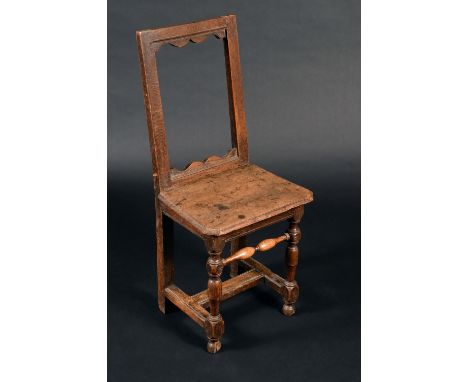 A early 18th century oak back stool, rectangular open back with wavy apron, boarded seat,  turned legs, H-stretcher, c.1730 