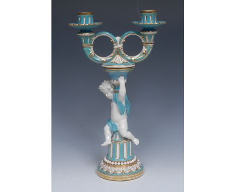 A Minton  two-branch, two-light figural candlestick, with fluted nozzles, leafy ring branches, supported on a scantily draped