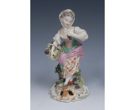 A Derby Patch Mark figure, Allegorical of Autumn, she stands, wearing a bonnet, bodice and floral skirt, holding a basket of 
