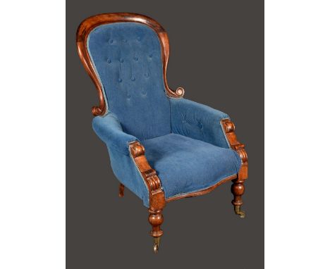 A Victorian mahogany spoon back armchair, stuffed-over upholstery, turned legs, ceramic castors, c. 1850