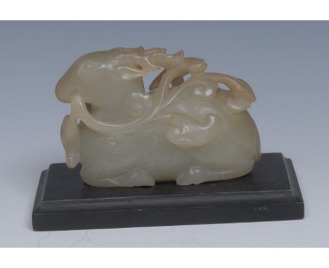 A Chinese pale green jade carving, of a recumbent stag holding lingzhi spray in its mouth, 9cm wide, hardwood stand