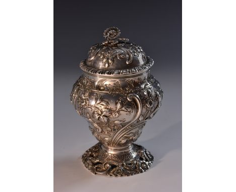 A George III silver inverted baluster tea caddy or sugar vase, domed cover with flower finial and gadrooned rim, well chased 