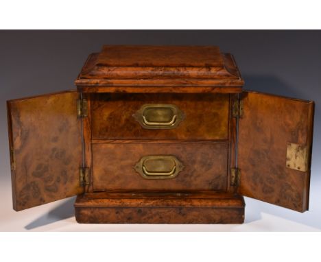 A Victorian burr walnut table-top cigar humidor, oversailing caddy top above a pair of doors centred by a baton, enclosing tw