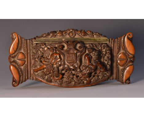 A late 18th century coquilla nut snuff box, hinged cover carved with allegorical figures flanking maritime arms, on a ground 