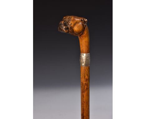 An early 20th century novelty silver-mounted walking stick, the pommel carved as the head of a boxer dog, inset glass eyes, s