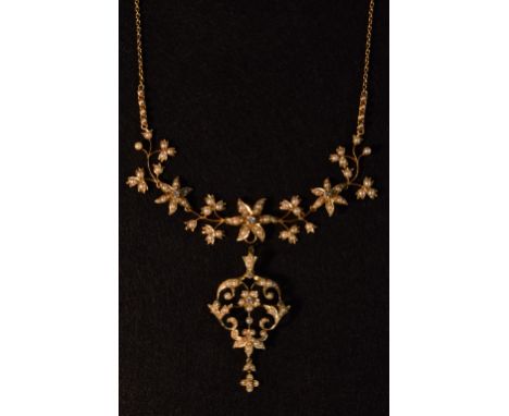 An Edwardian 15ct gold diamond and seed pearl pendant necklace and brooch suite, the necklace with three graduating flower he