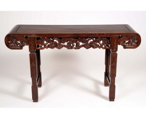 A Chinese hardwood altar table, rectangular top with scroll ends, above a deep frieze pierced and carved with scrolling cloud