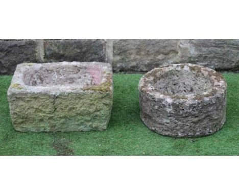 A SANDSTONE TROUGH of rough hewn circular form, 15 1/2" x 8", together with another of oblong form, 18" x 12 1/2" x 9" (2) (E
