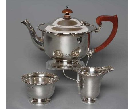 A SILVER THREE PIECE TEA SERVICE, maker Grant &amp; Son, Birmingham 1938, of rounded cylindrical form with everted pie-crust 