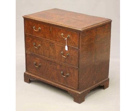 A POLLARD OAK VENEERED CHEST, the moulded edged and banded top with stringing, three long drawers with brass bale handles, on