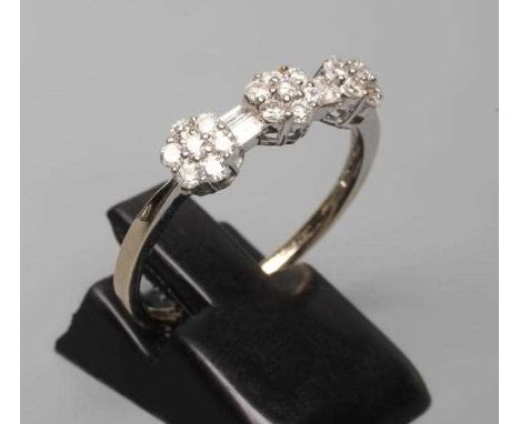 A DIAMOND TRIPLE CLUSTER RING, the seven stone small clusters with two pairs of baguette cut stones to a plain 18ct gold shan