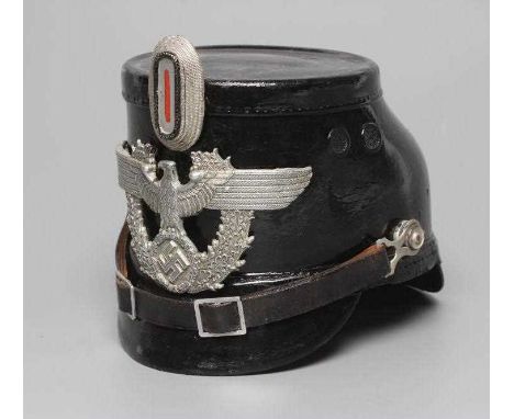 A SECOND WORLD WAR GERMAN POLICE SHAKO, with large metal Third Reich eagle badge, peak, leather chin strap and light brown le