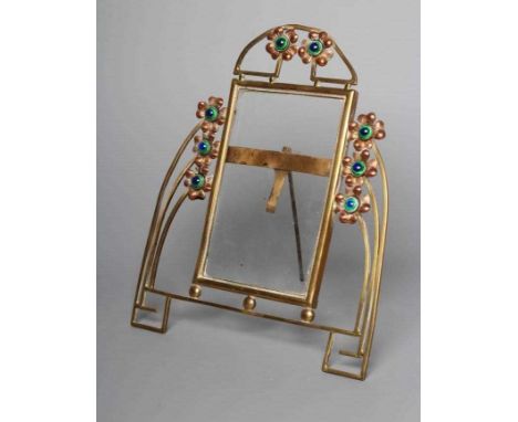 A GERMAN JUGENDSTIL BRASS STRUT BACK PHOTOGRAPH FRAME, c.1900, the oblong glass plate with arched top and buttress sides and 